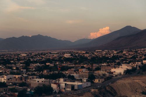 Free A tranquil view of a townscape at dusk with mountains in the background. Stock Photo
