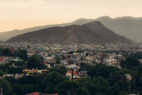 Free Scenic aerial view of a Mexican town with mountains at twilight. Stock Photo