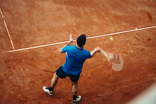 Free Aerial view of a tennis player serving during a match on a clay court in Melbourne, Australia. Stock Photo