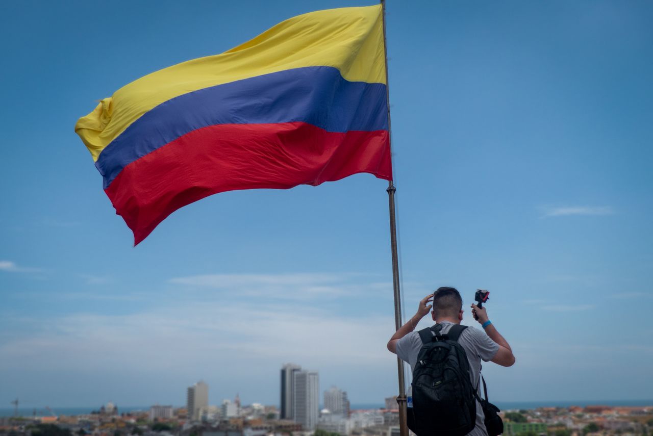 back view of a man photographing the colombian flag in cartagena colom