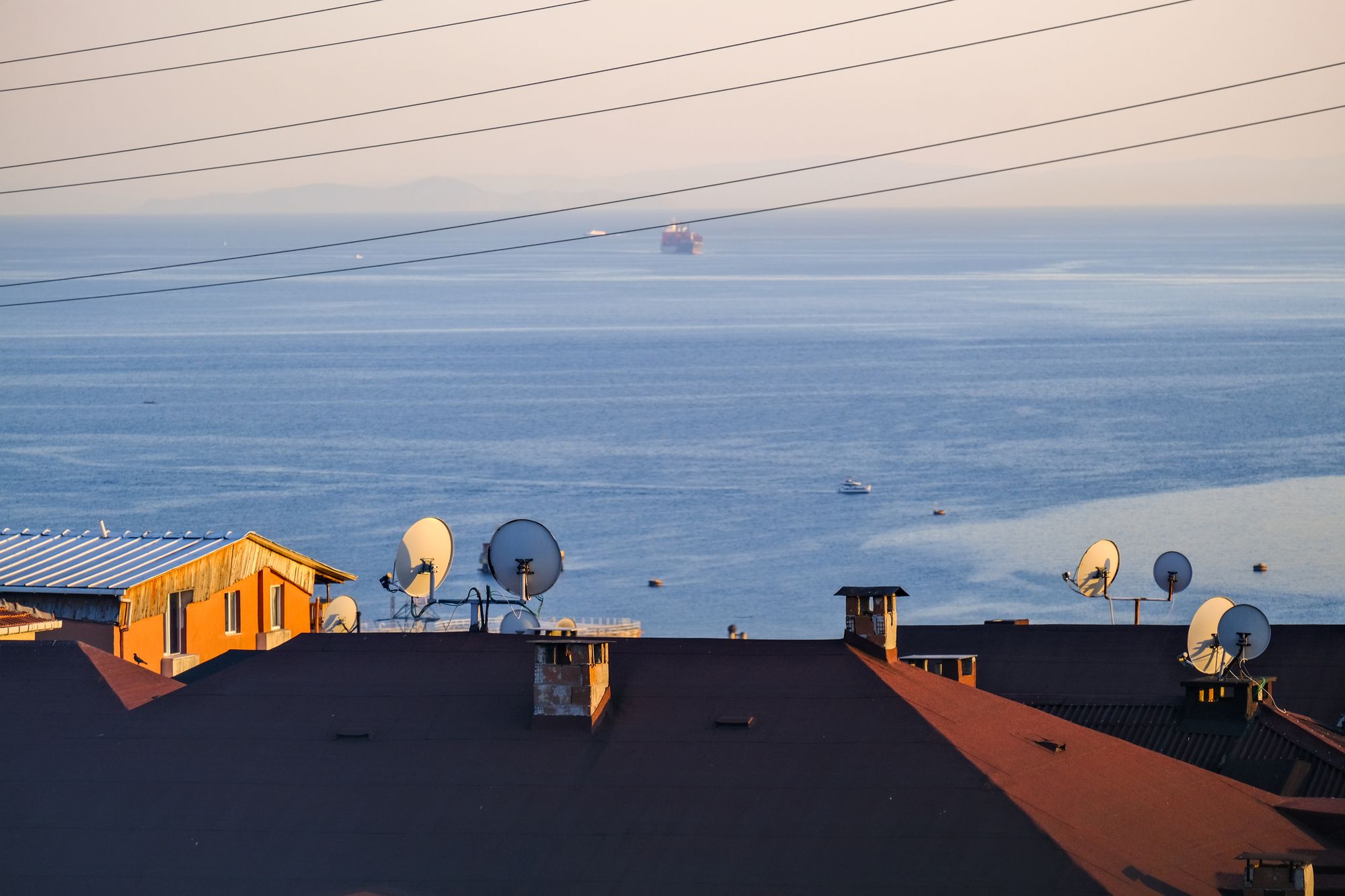 Antena parabólica blanca de internet satelital instalada en el techo de una casa