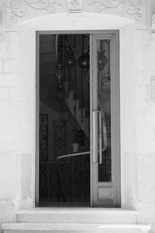 Бесплатное стоковое фото с вертикальный выстрел, дверной проем, оттенки серого
