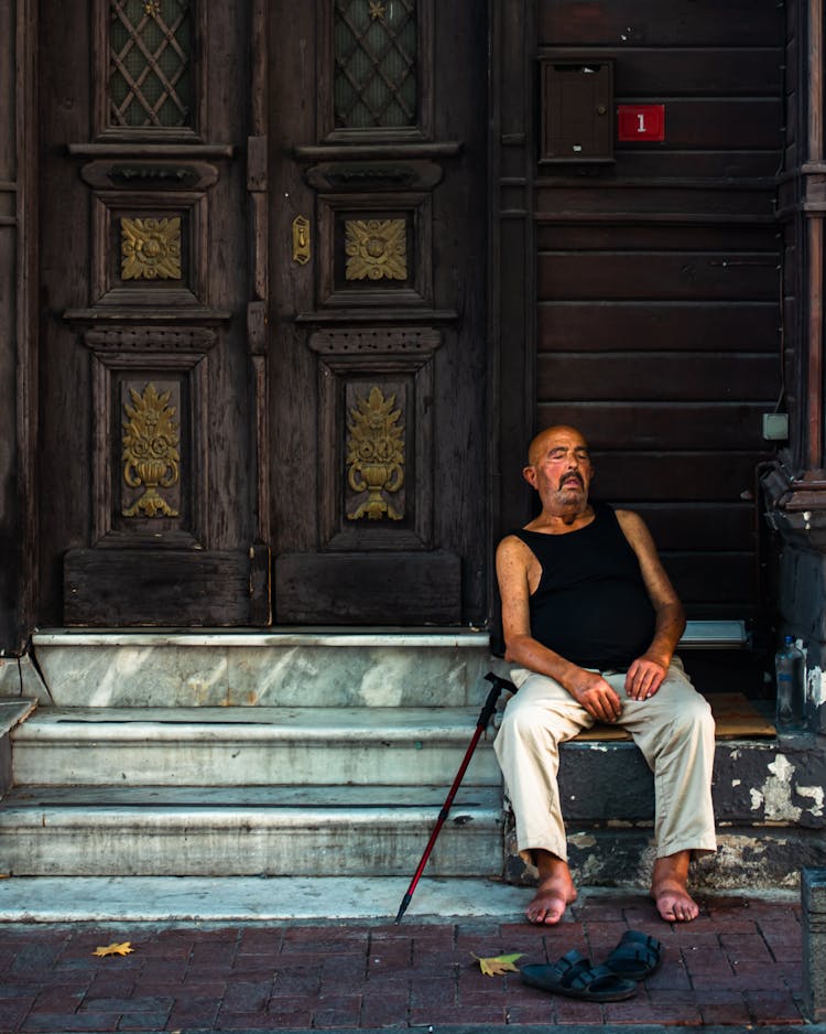 Man Sitting On Stairs Near Door