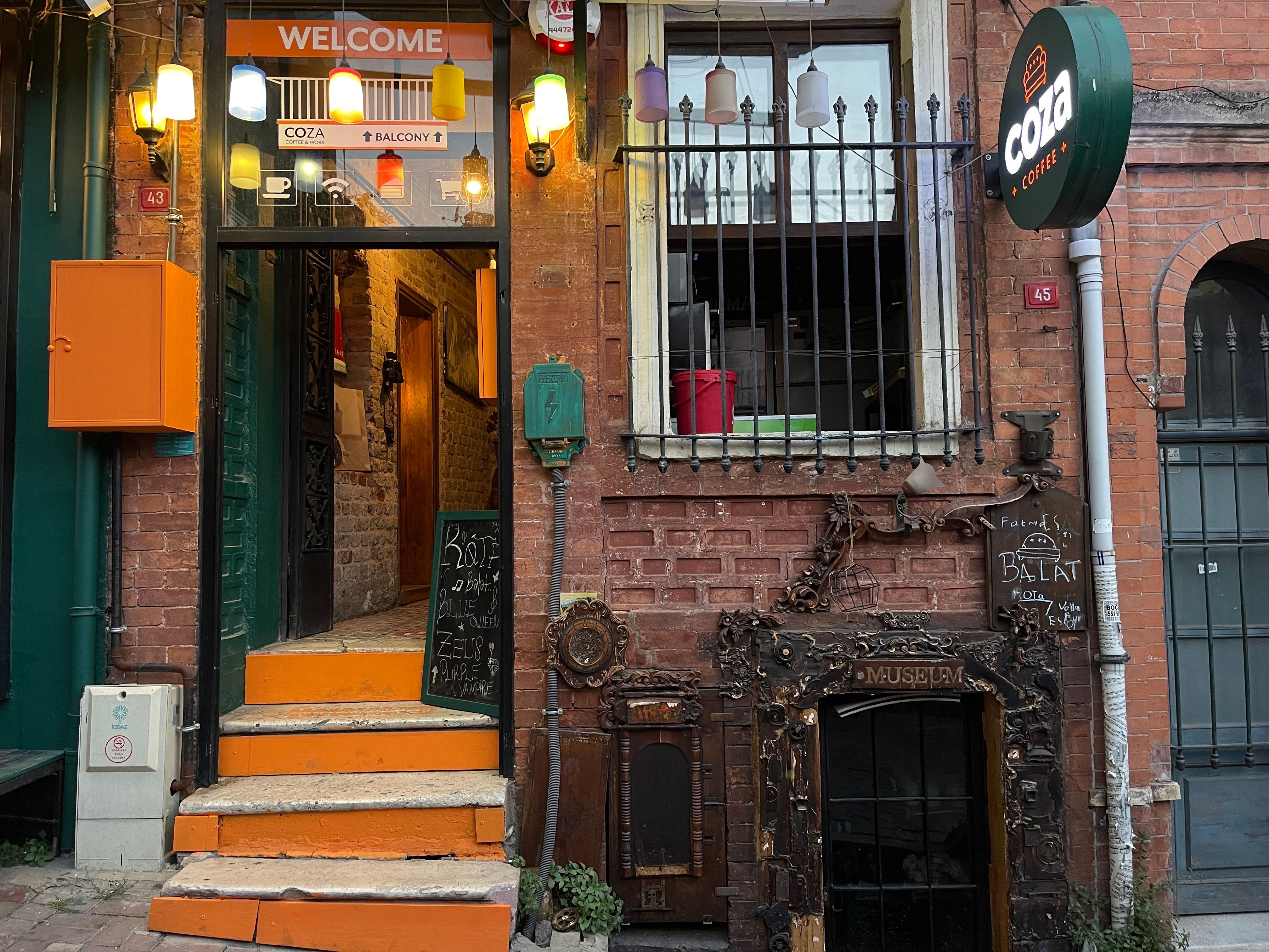 Inviting entrance to a café with eclectic storefront, vibrant decor, and cozy ambiance.