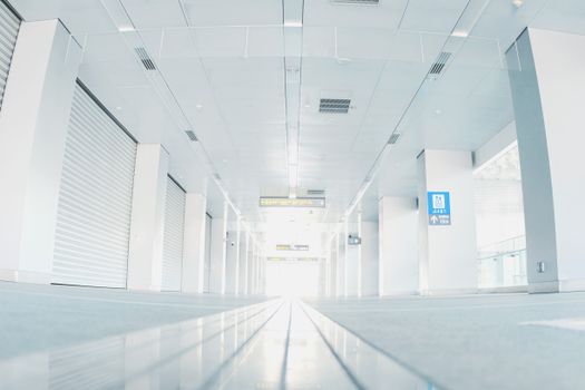 Low angle shot of an empty metro station corridor with steel rolling doors and signage.
