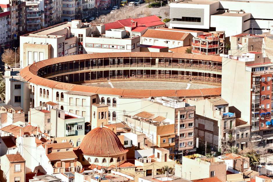 Aerial view of the Alicante bullring surrounded by urban architecture, showcasing the cityscape of Alicante, Spain.