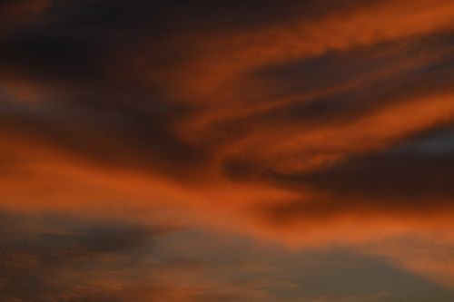 Free A striking image of orange clouds against a dark sky, capturing a dramatic twilight scene. Stock Photo
