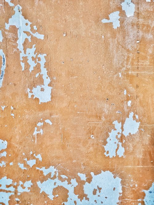 Free Close-up of chipped white paint on a rustic concrete wall with a textured surface. Stock Photo