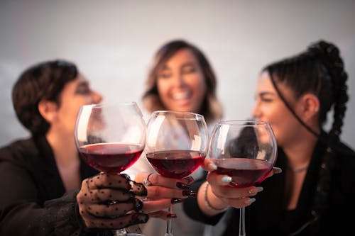 Shallow Focus of Three People Holding Wine Glasses