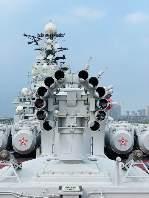 Free Close view of a battleship's cannons in Tianjin harbor, showcasing military might under a blue sky. Stock Photo