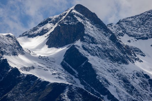 Close-up of snow-covered mountain peaks under a clear sky, showcasing winter beauty.
