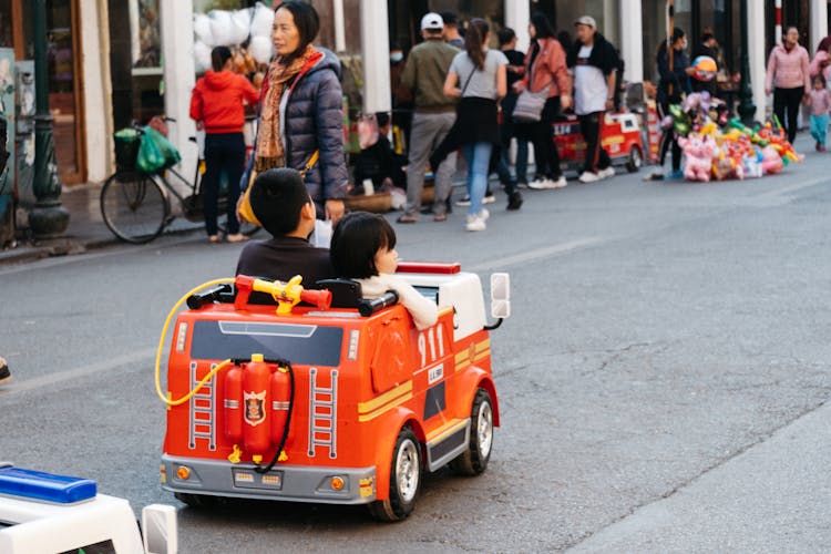 Children Driving A Fire Engine Toy