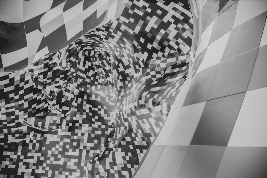 Abstract image featuring a black and white checkered pattern with pixelated forms.