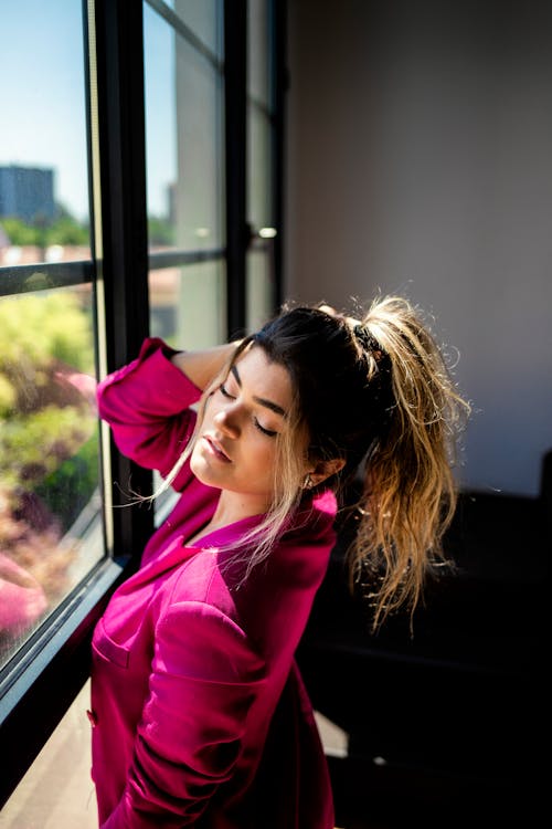 Woman Standing Beside a Window