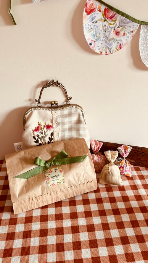 Free A delightful arrangement of handmade bags and decor on a checkered table, featuring floral patterns and a ribbon. Stock Photo