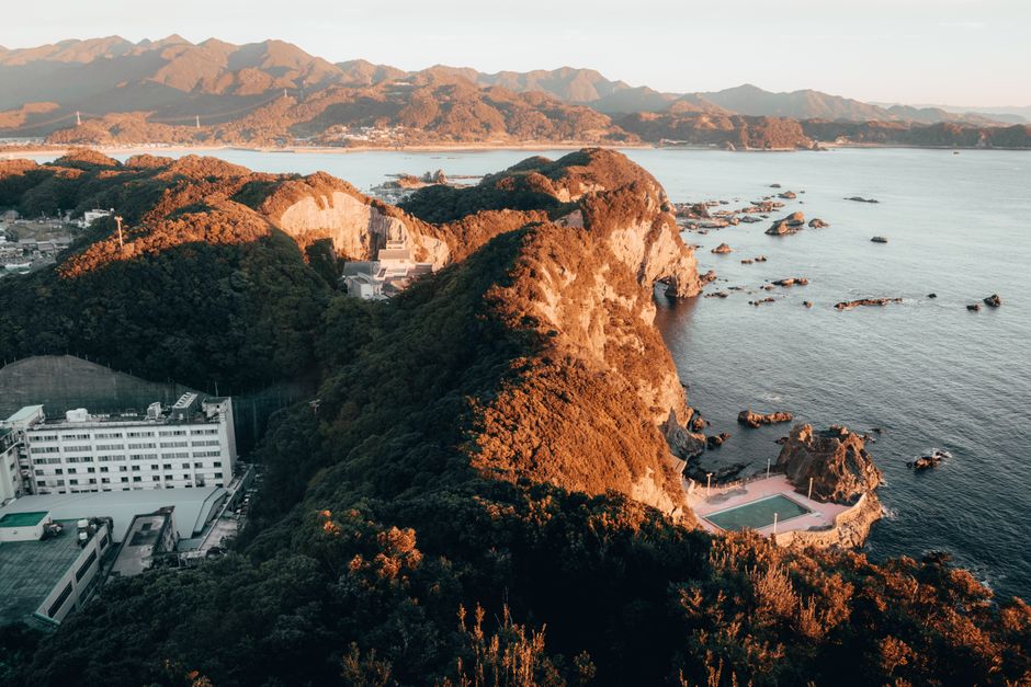 Aerial view of stunning mountainous coastline and ocean at sunset. Perfect for travel inspiration.