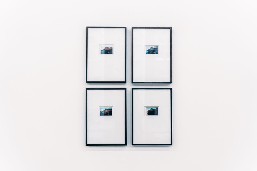 Four black frames arranged on a white wall