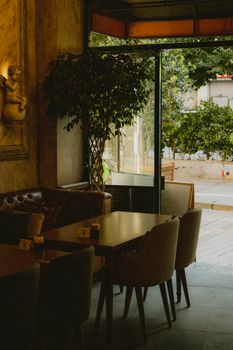 A warmly lit cafe interior featuring comfy seating and a view of the outdoors.