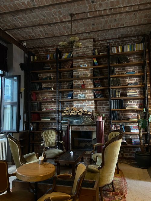 Free Charming library setting with bookcases, vintage chairs, and a rustic fireplace. Stock Photo