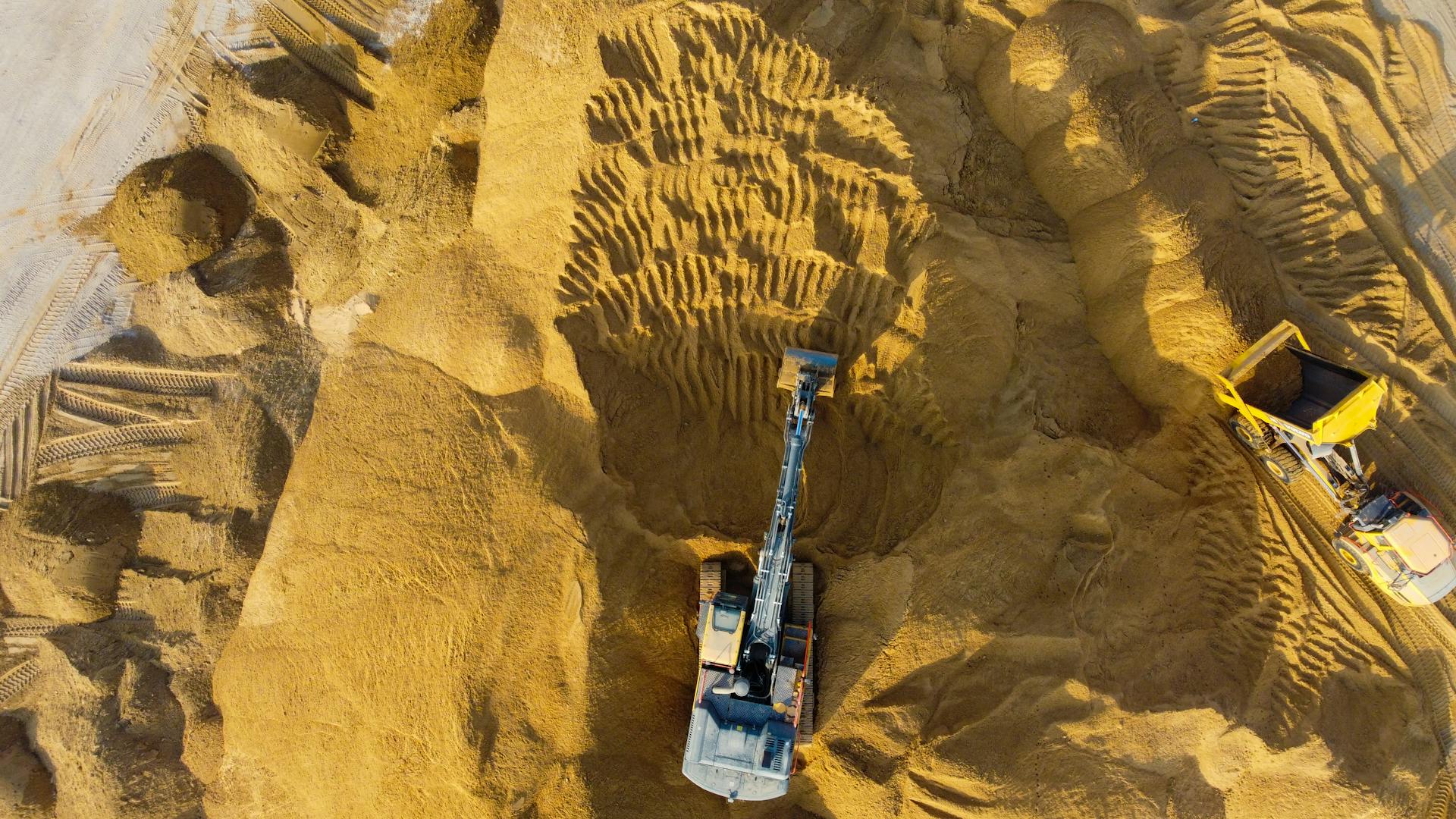 Drone shot of excavators at work in sandy construction site, Ashdod, Israel.