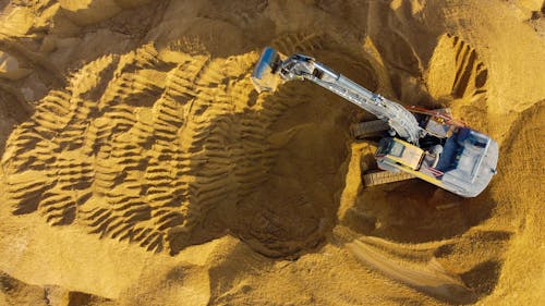 Excavator Digging Mound of Sand