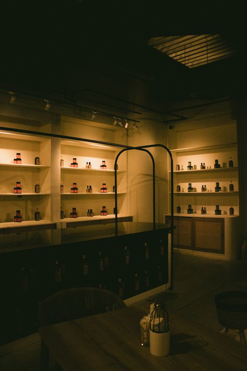 Free A warm and inviting interior of a dimly lit bistro in Dubai, showcasing beautifully arranged shelves of bottles. Stock Photo