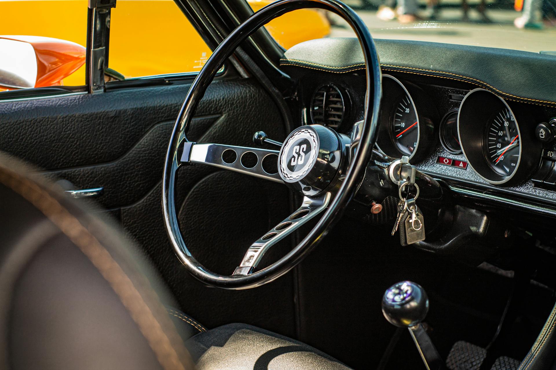 Close-up of a vintage car interior focusing on the SS emblem steering wheel and dashboard.