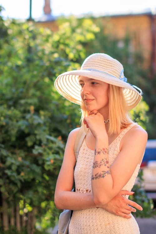 A Woman Wearing Sun Hat with Her Hand on Her Chin