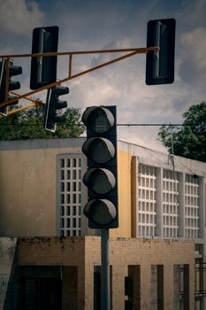 Traffic light in front of a concrete building under a cloudy sky in Mérida, Venezuela.