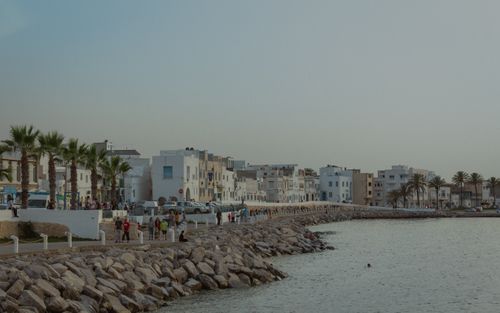Free Beautiful coastal view in Mahdia, Tunisia, with palm trees and white buildings lining the shore. Stock Photo