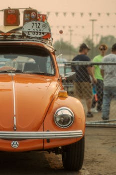 Classic orange Volkswagen Beetle parked at an event in Reno, NV, showcasing vintage style.