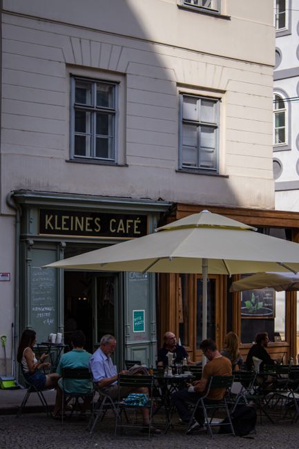 Cozy outdoor café with visitors enjoying drinks in a European city.