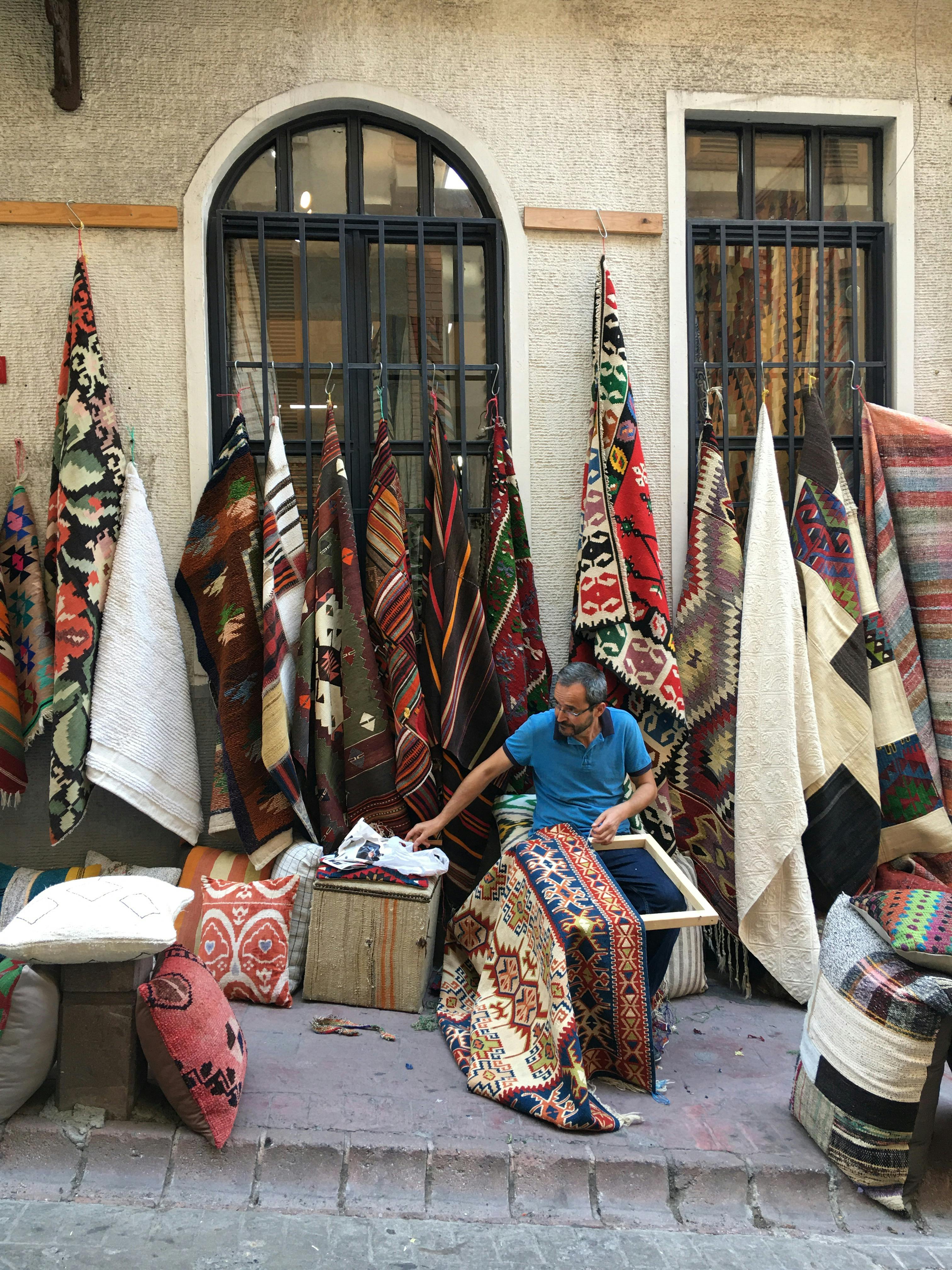 Man Sewing Carpets on Street · Free Stock Photo