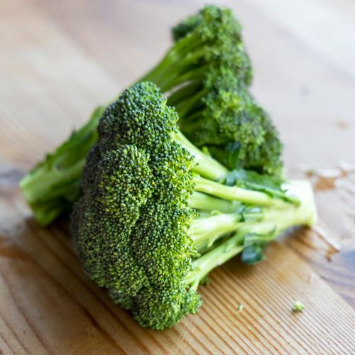 Free Close-up of fresh broccoli on a wooden table, emphasizing healthy eating. Stock Photo