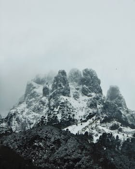 Foggy snow-capped mountain in Araucanía, Chile, showcasing nature's rugged beauty and serene atmosphere.