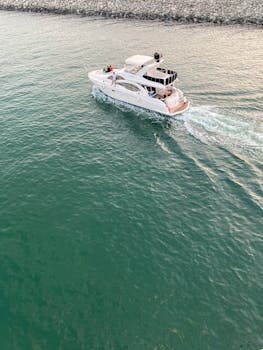 Aerial view of a yacht cruising on calm green water, perfect for travel and vacation themes.