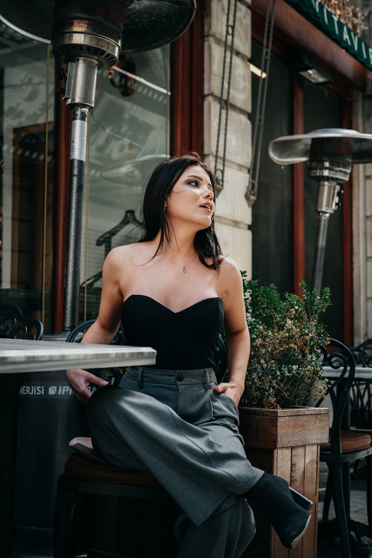 Young Woman Sitting At The Outside Bar Table