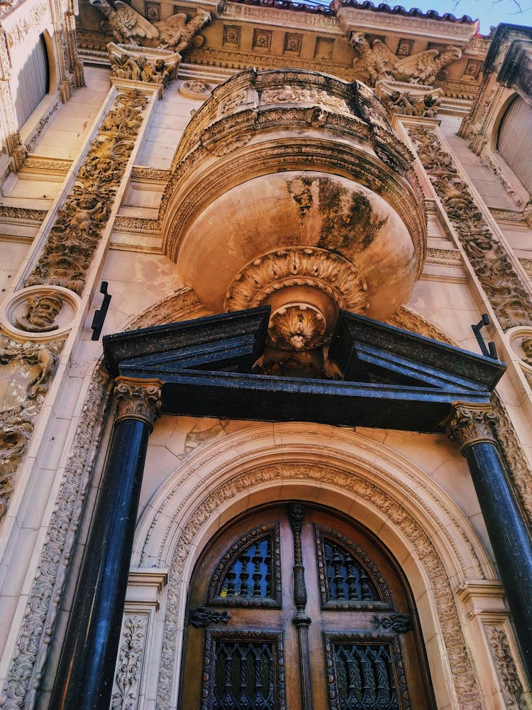 Low Angle Shot Of A Decorative Facade With A Portal And Balcony