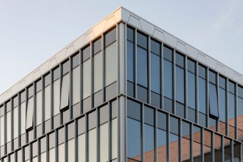 Free Contemporary building with glass facade reflecting sunset in Vilnius, Lithuania. Stock Photo