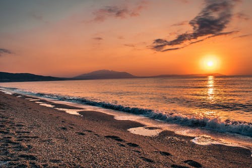 бесплатная Серый песок возле водоема во время заката Стоковое фото
