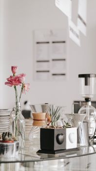 Stylish cafe interior featuring modern decor with flowers and sleek vases on a table.