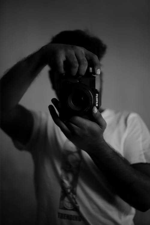 Grayscale Photo of a Man Taking a Picture