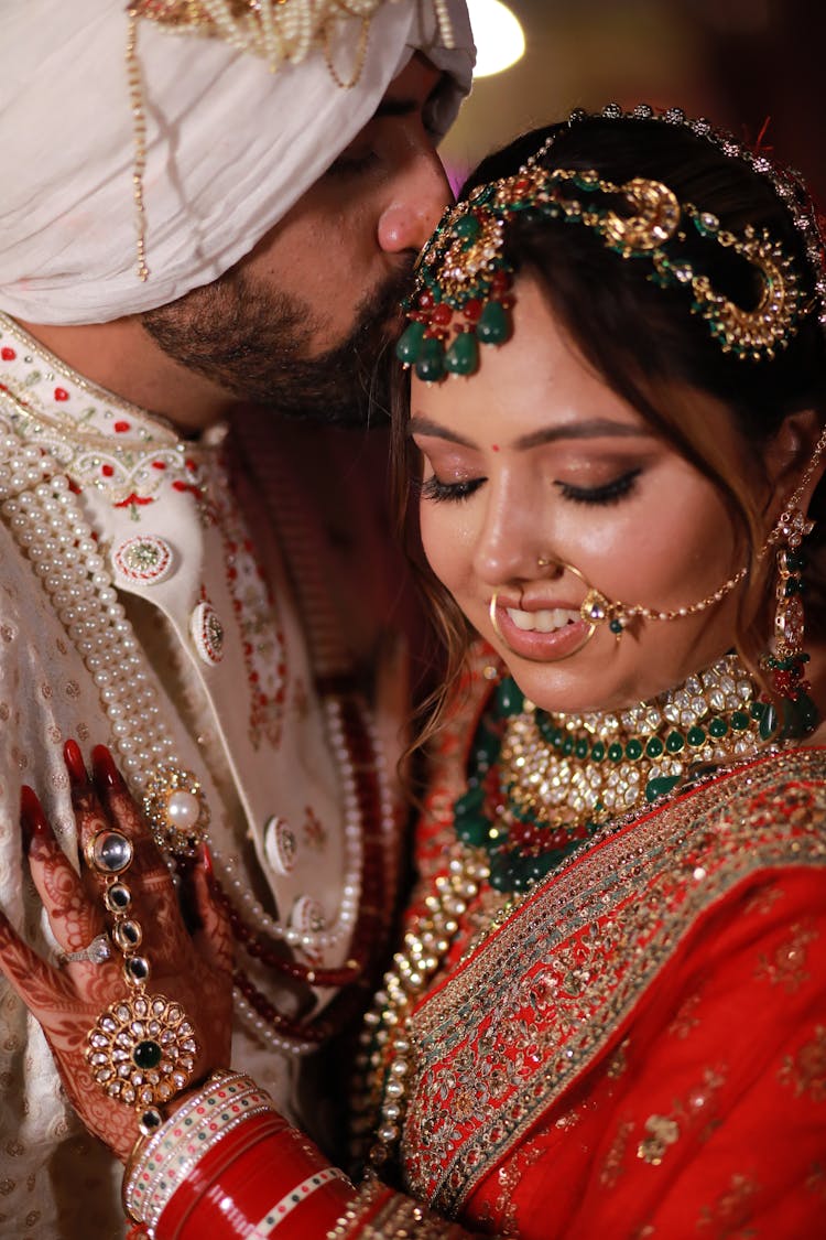 A Man Kissing Her Partner On The Head