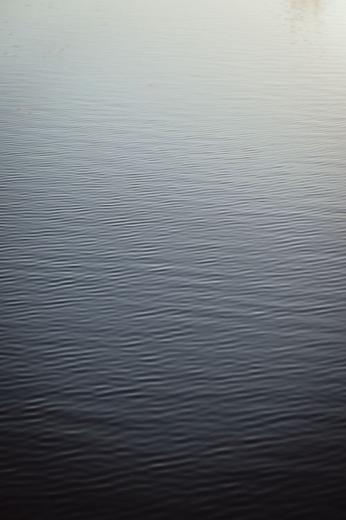 Free Serene view of rippling water at dusk, creating a peaceful and minimalistic scene. Stock Photo