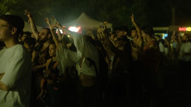 Energetic concert-goers enjoying a lively night event outdoors in Istanbul, Türkiye.
