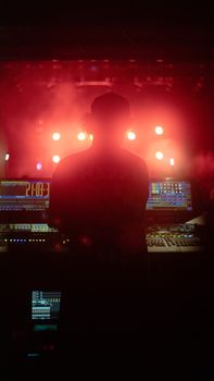 Silhouette of a DJ performing amidst vibrant lights in an İstanbul concert.