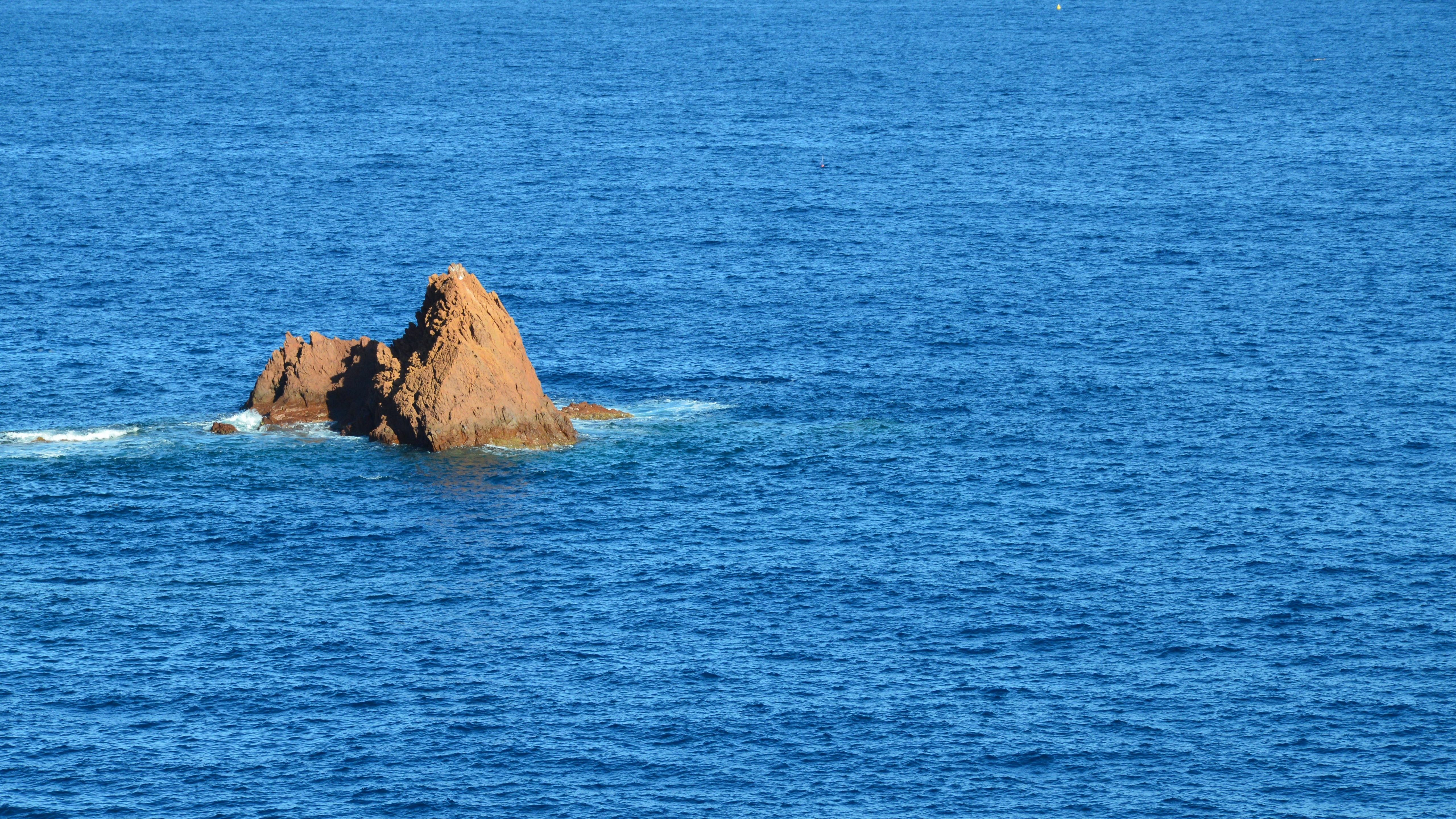 Photo of a Rock Formation in the Middle of an Ocean · Free Stock Photo