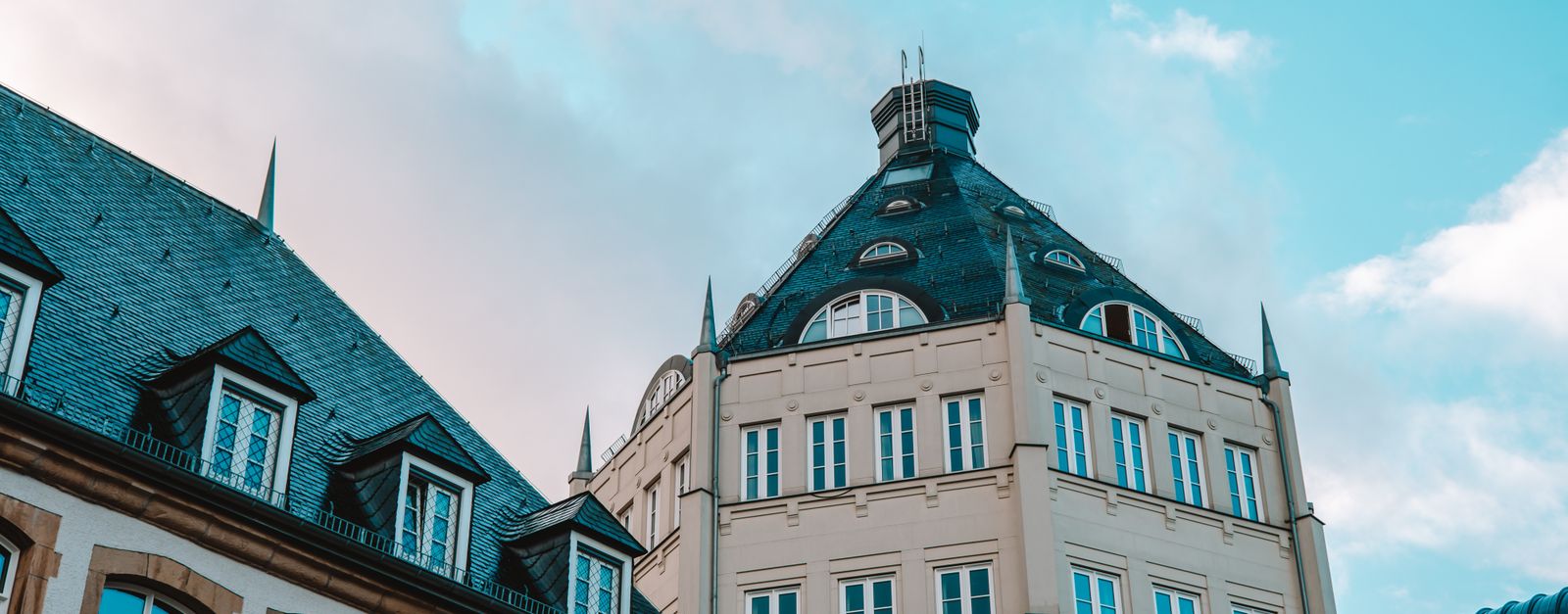 A historic building in Luxembourg stands against a striking blue sky, showcasing its unique architecture.