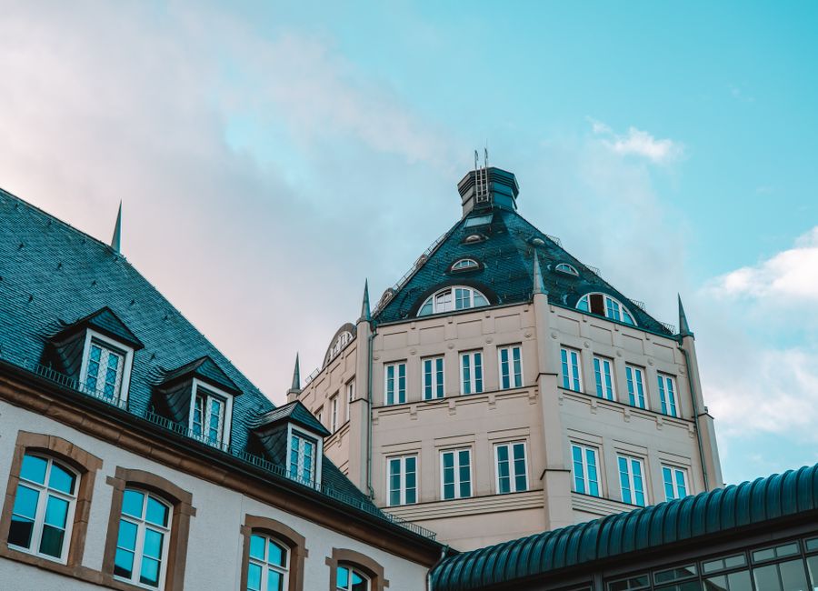 A historic building in Luxembourg stands against a striking blue sky, showcasing its unique architecture.