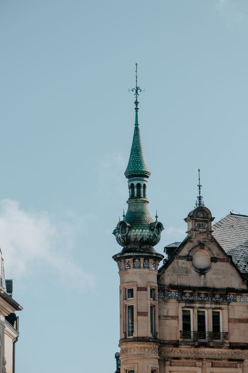 Free Elegant historical European building facade with intricate spire against clear sky. Stock Photo